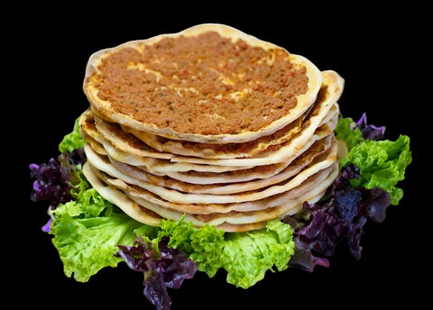 Stack of flatbreads with a side of salad on a white plate